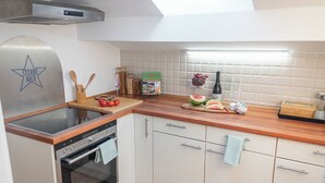 A modern kitchen with a built-in stove, oven, and a stainless steel range hood. - La Casa Bonita, Charming family apartment with 3 bedrooms and sun terrace (Bad Aibling)