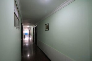 A hallway with doors on both sides, a light switch, and a framed picture on the wall. - Jiangyang Business Hotel (Shanghai Shuangyang Road) (Shanghai)
