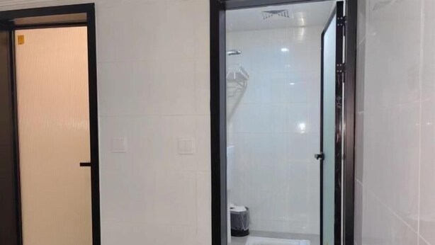 Un bagno con cabina doccia in vetro, asciugamano e water.