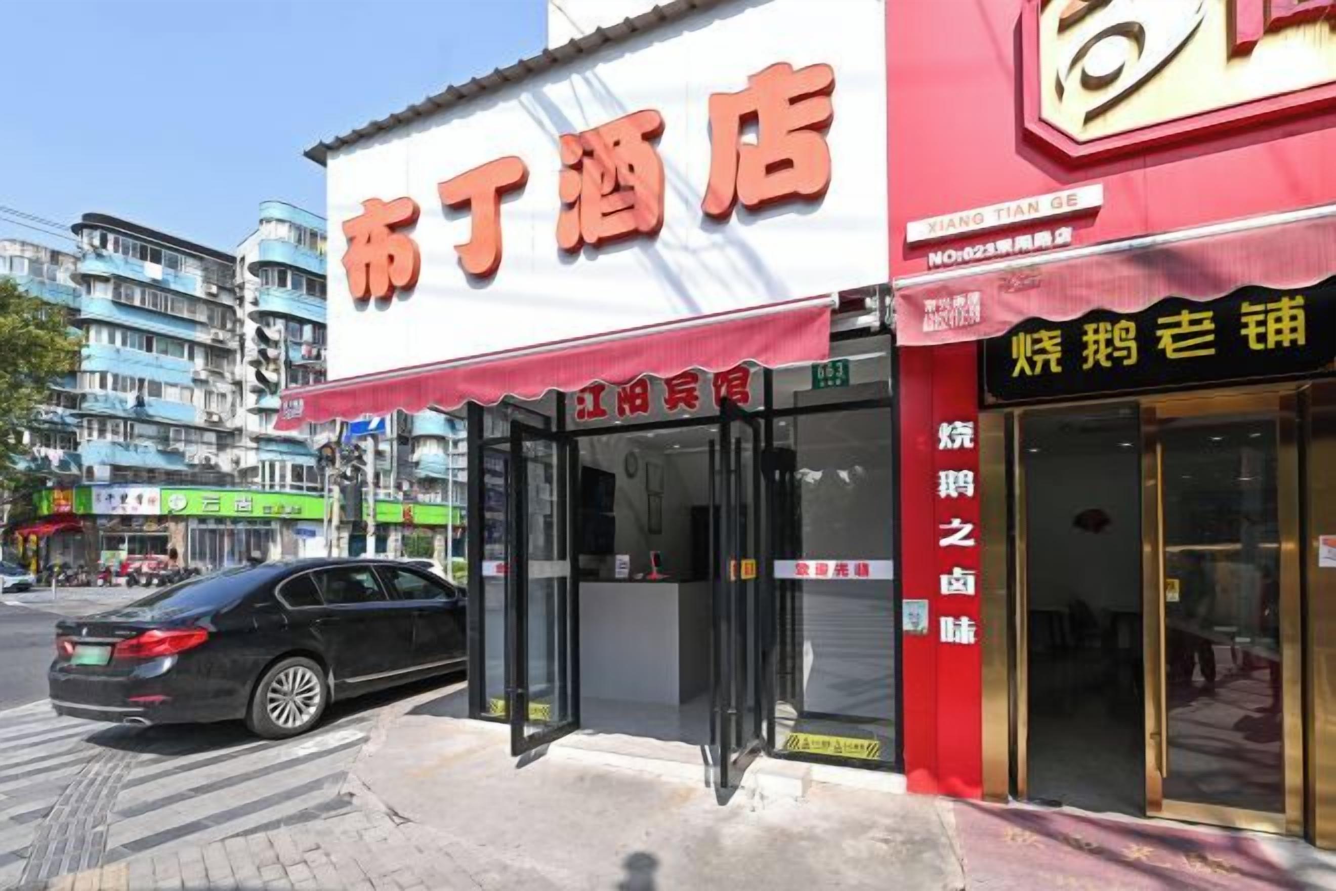 A hotel with a red awning and a sign in Chinese characters.