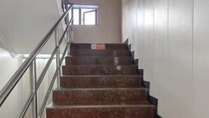 Una scala con ringhiere in metallo e gradini in marmo che conduce a un piano superiore.
