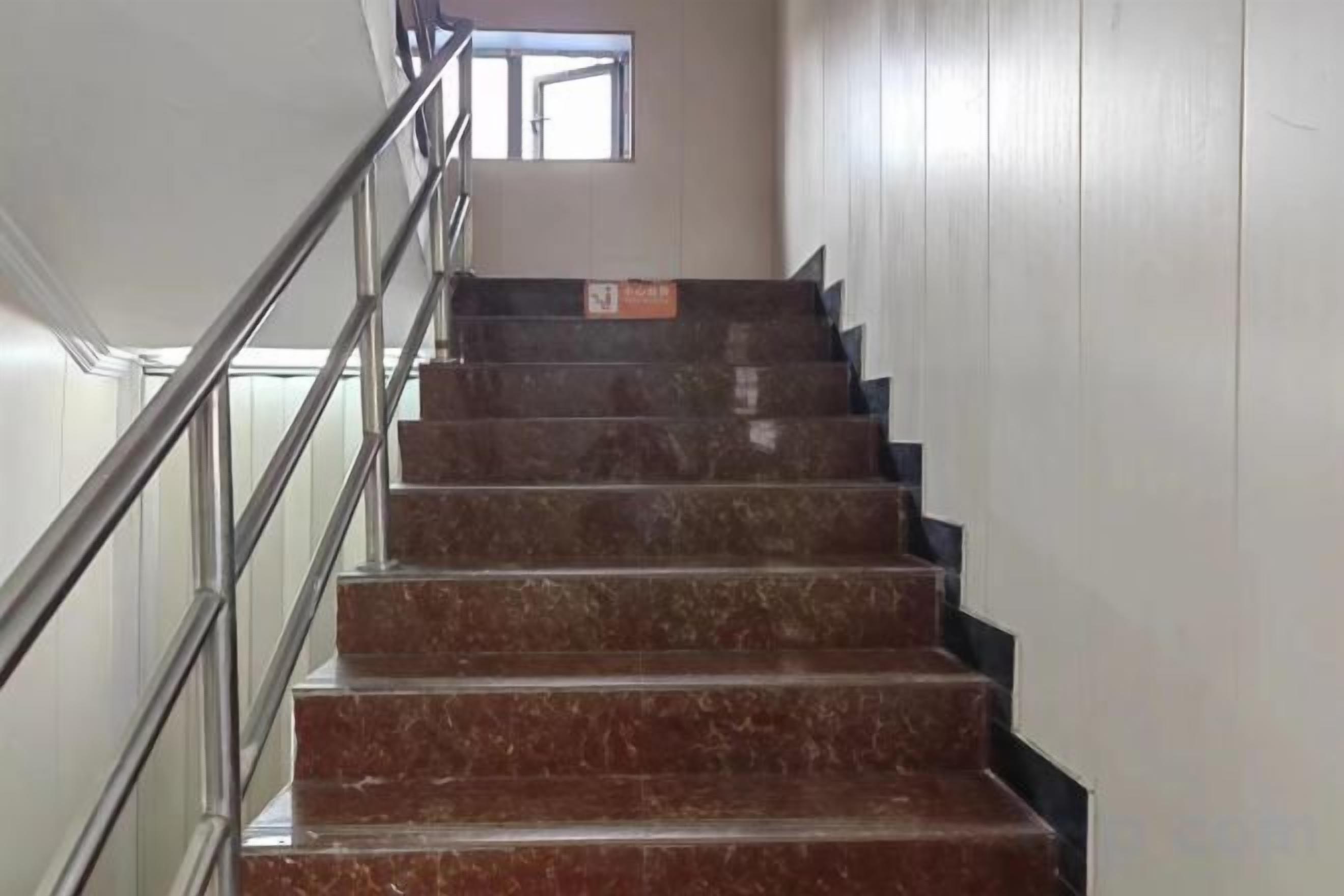 A staircase with metal railings and a window at the top.