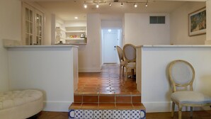 A spacious living area with a kitchen, a dining area with chairs, and a staircase leading to another room. - Perfect Palm Beach Location #2, spacious Condo, WiFi, AC in fabulous Palm Beach. (Palm Beach)