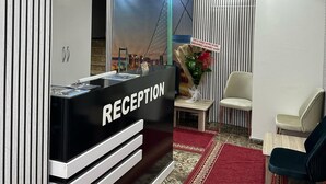 A reception area with a reception desk, chairs, a red carpet, and a view of a bridge. - Ist Suit Otel (Van)