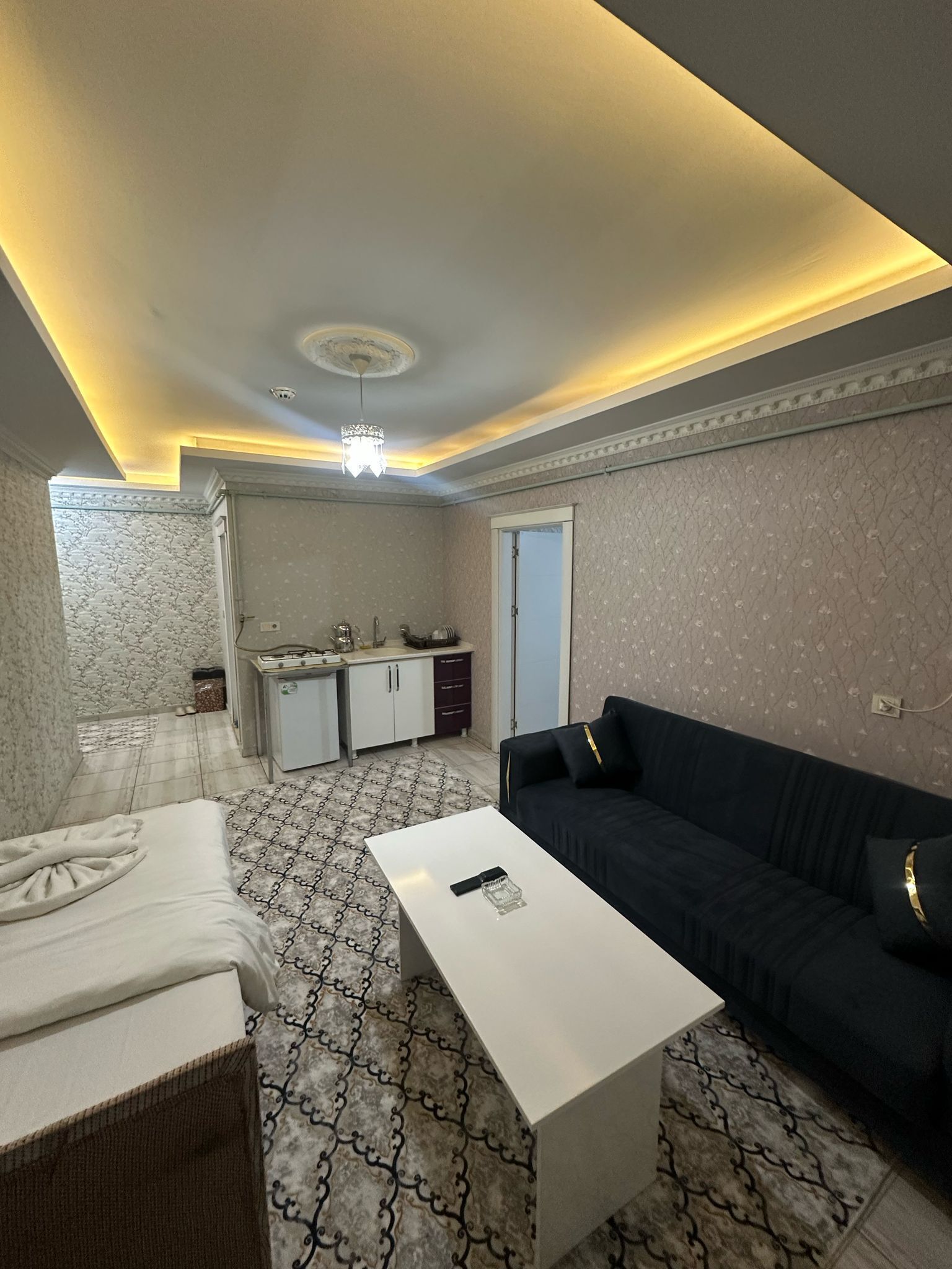 A modern living room with a sofa, a coffee table, and a patterned rug.