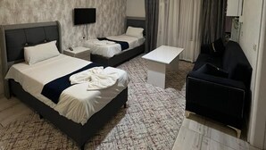 A hotel room with two beds, a desk, a chair, a flat-screen TV, and a chandelier. - Ist Suit Otel (Van)