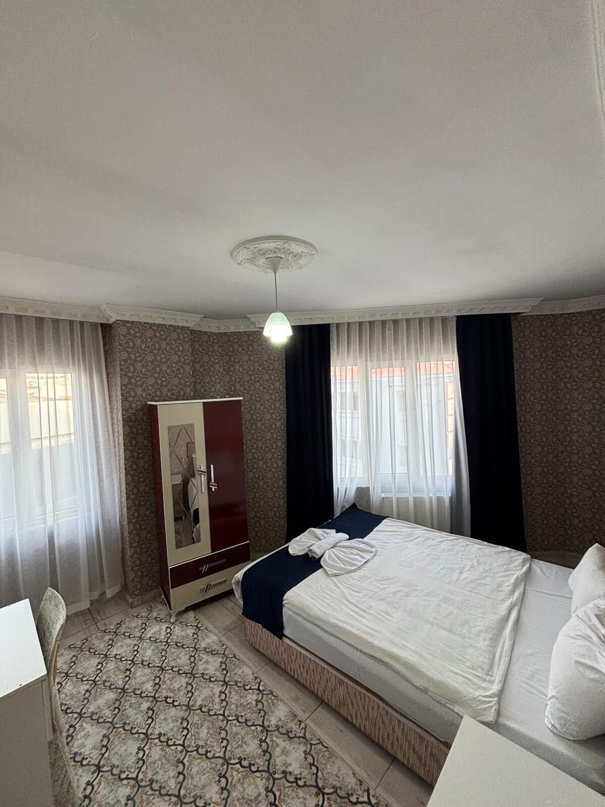 Una habitación de hotel con una cama, un armario y un escritorio.