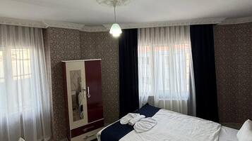 Una habitación de hotel con una cama, un armario y un escritorio.
