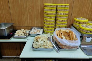A buffet table with various food items, including trays of pastries and containers of bread. - 7 Days Inn (Zibo Zhou Village Gushangcheng Street) (Zibo)