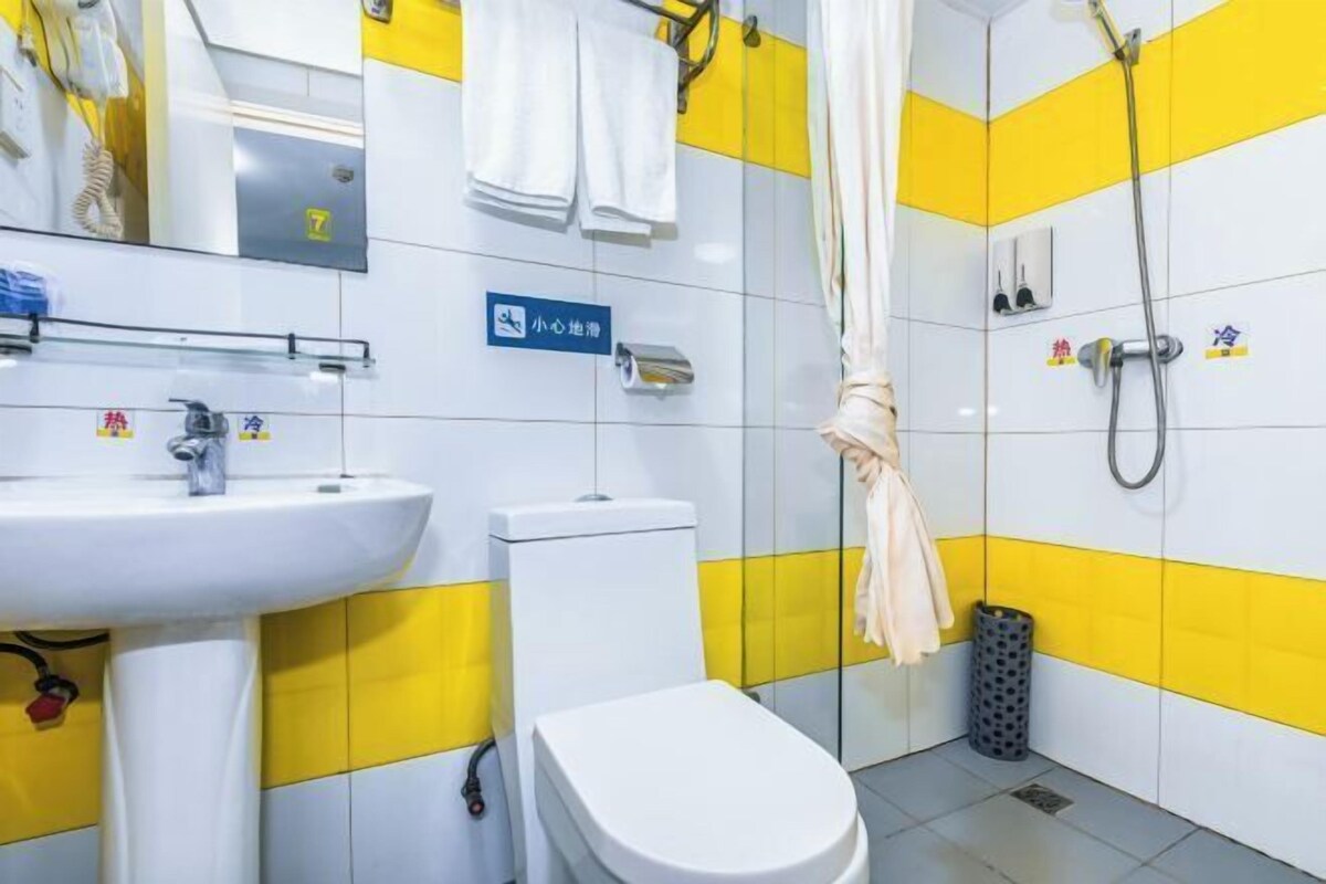 Un baño con lavamanos, inodoro y zona de ducha.