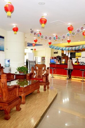 A hotel lobby with a reception desk, wooden furniture, and red lanterns. - 7 Days Inn (Zibo Zhou Village Gushangcheng Street) (Zibo)