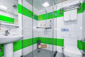 Un baño con mampara de vidrio, lavamanos, inodoro y zona de ducha.