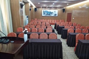 A conference room with rows of chairs, a podium, and a large screen. - 7 Days Inn (Zibo Zhou Village Gushangcheng Street) (Zibo)