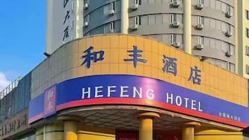 Un hotel con un letrero llamativo en chino e inglés que indica el nombre 'HEFENG HOTEL'.