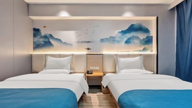A hotel room with two beds, a nightstand, a wall-mounted artwork, and a wooden floor. - 7 Days Inn (Zibo Zhou Village Gushangcheng Street) (Zibo)