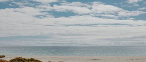 A beach with a clear sky and calm sea.