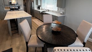 Una cocina moderna con una isla central, mesa de comedor y sillas.