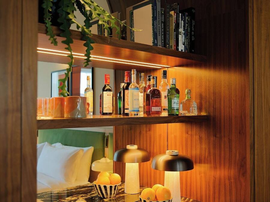 Een houten plank met verschillende drankflessen en een schaal mandarijnen.