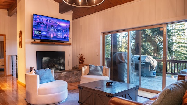 A cozy living room with a fireplace, comfortable seating, and a large TV screen. - Bear Lodge (Tahoe City)