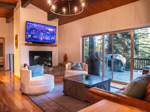 A cozy living room with a fireplace, comfortable seating, and a large TV screen. - Bear Lodge (Tahoe City)
