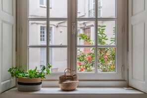 A window with a view of a building and a plant.