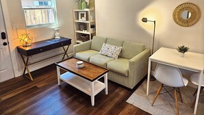 Un salon confortable avec un canapé, une table basse et un bureau avec une lampe.
