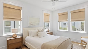 A bedroom with a bed, bedside tables, a ceiling fan, and windows with blinds. - Family-friendly Coastal Escape Grill, Decks & More! (Santa Rosa Beach)