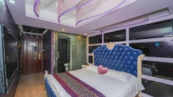 A bedroom with a large bed, a glass door, and a view of the city.