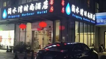 Un hotel con un letrero que dice 'Dripping Harbour Hotel' tanto en inglés como en chino.