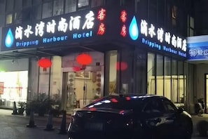 Un hotel con un letrero que dice 'Dripping Harbour Hotel' tanto en inglés como en chino.