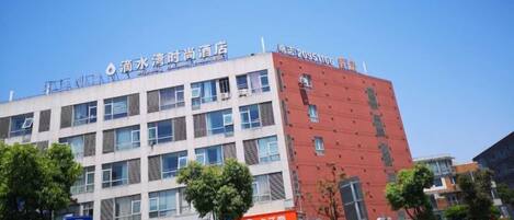 A multi-story building with signage indicating a hotel and a parking area.