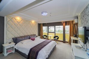 A hotel room with a large bed, a TV, a desk, and a balcony with a view. - Dishuiwan Fashion Hotel (Shanghai)