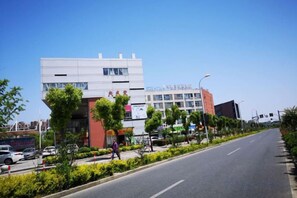 A modern building with a flat roof and a large entrance. - Dishuiwan Fashion Hotel (Shanghai)