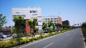 A modern building with a flat roof and large windows, surrounded by greenery and a clear sky. - Dishuiwan Fashion Hotel (Shanghai)