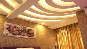A room with a unique ceiling design, a large abstract painting on the wall, and a golden curtain. - Dishuiwan Fashion Hotel (Shanghai)