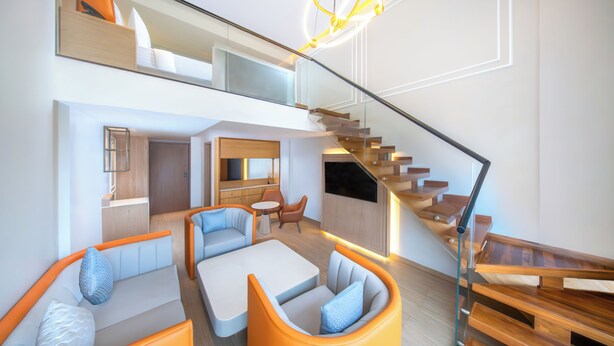 Een modern interieur met een trap, zithoek en keuken.
