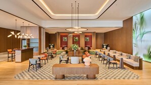 A modern lobby with a central round table, seating arrangements, and a reception desk. - Hilton Garden Inn Zhongshan South (Zhongshan)