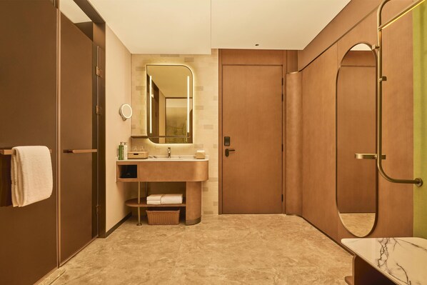 Une salle de bain moderne équipée d’un meuble-lavabo, d’un miroir, d’un porte-serviettes et d’un espace douche.