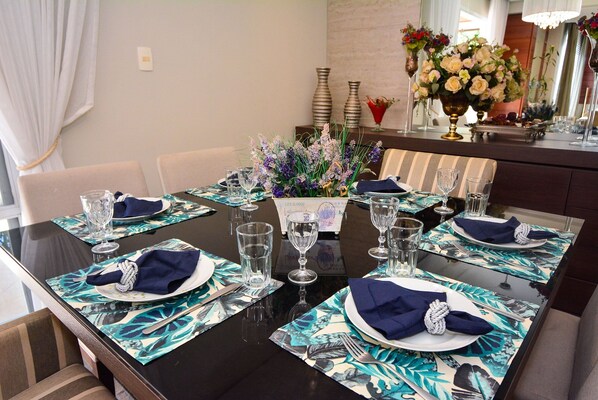 Une table à manger dressée, avec la vaisselle, les couverts et les serviettes en place.