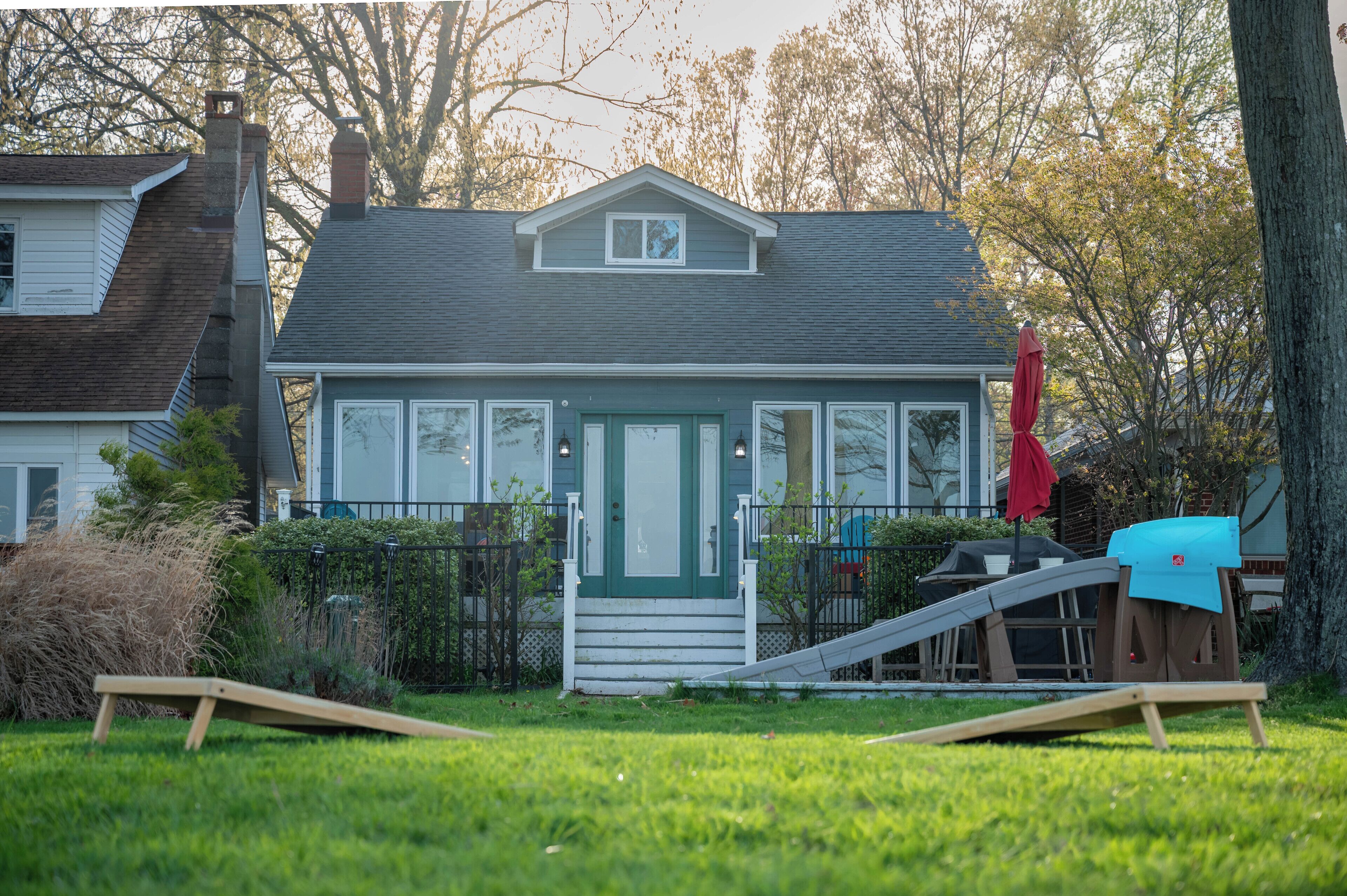 A house with a front porch, a small deck, and a slide.