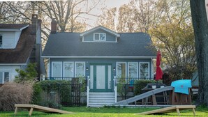 A house with a front porch, a small deck, and a slide.