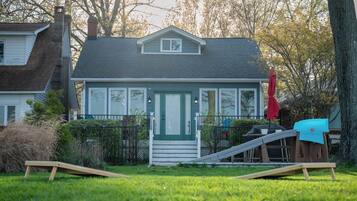 A house with a front porch, a small deck, and a slide.