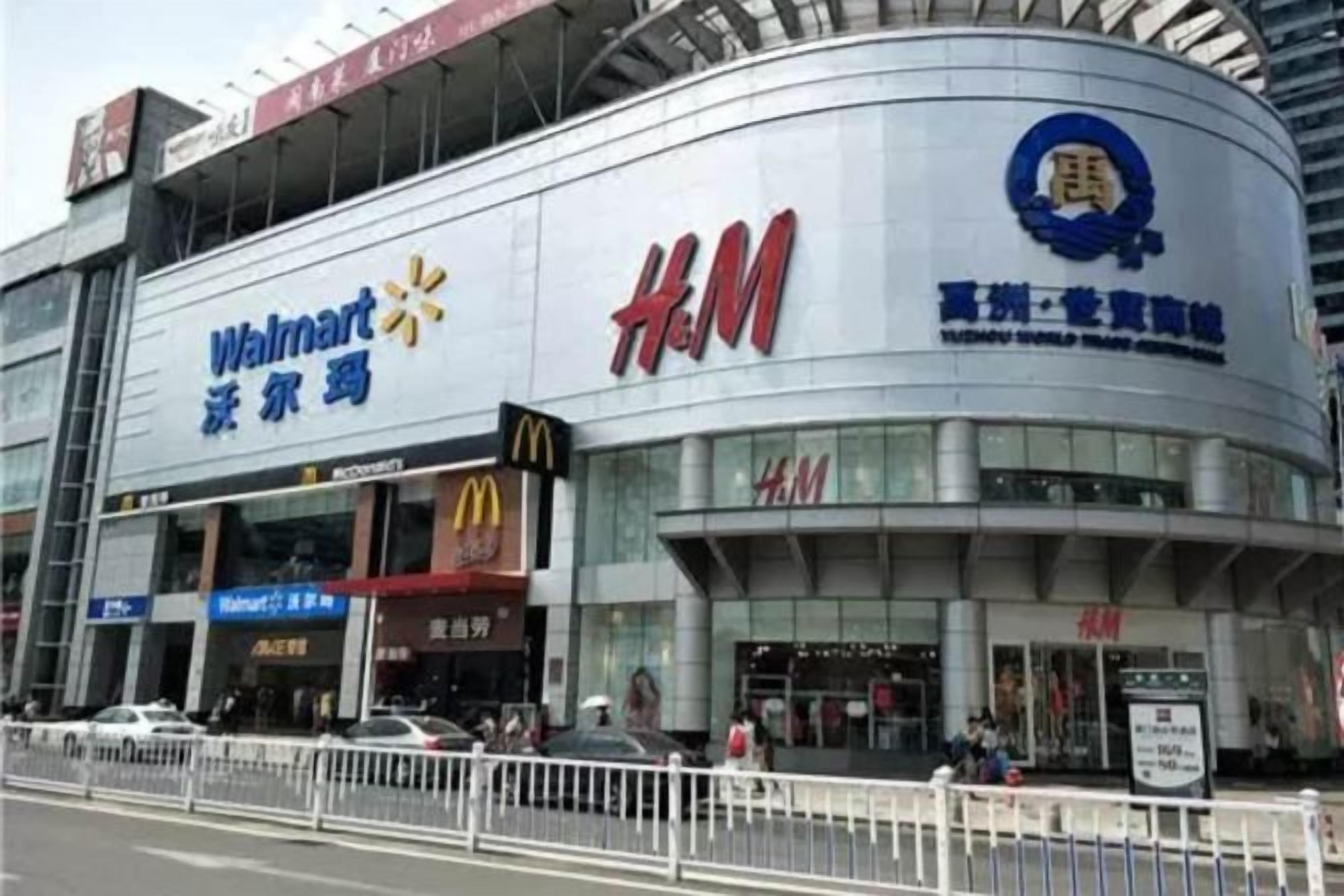 Um grande edifício comercial com placas de destaque para Walmart e H&M.