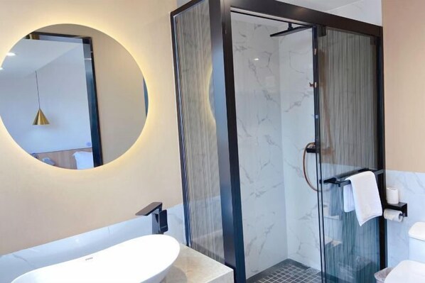 A modern bathroom with a glass-enclosed shower, a round mirror, and a white sink. - Super 8 Hotel Premier (Xiamen Railway Station) (Xiamen)