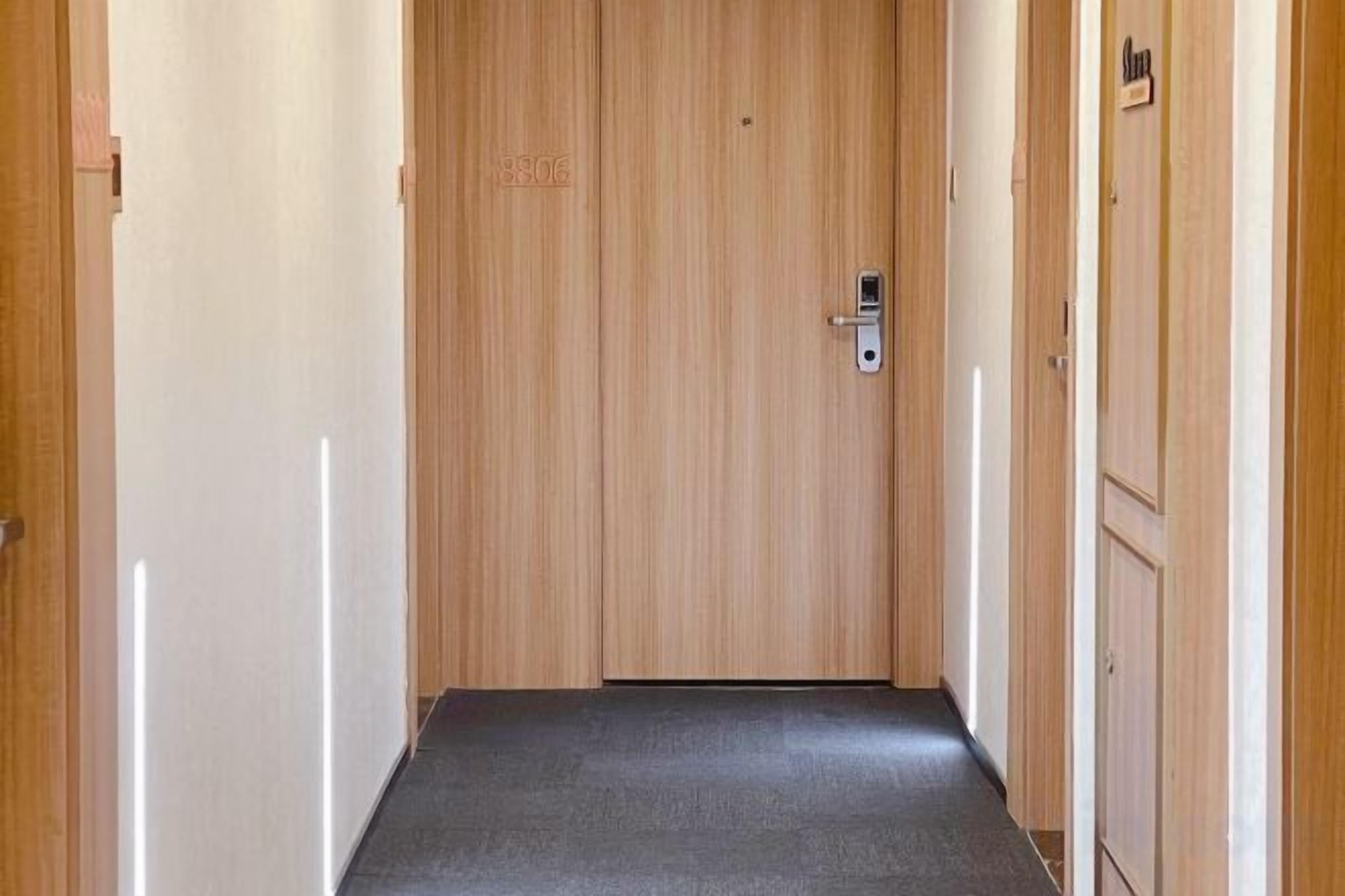 A hallway with wooden doors and a carpeted floor.