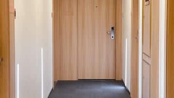 A hallway with wooden doors and a carpeted floor.