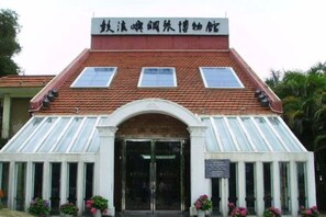 Un bâtiment doté d’un toit en pente, d’une entrée centrale avec des portes vitrées et d’une enseigne au-dessus.