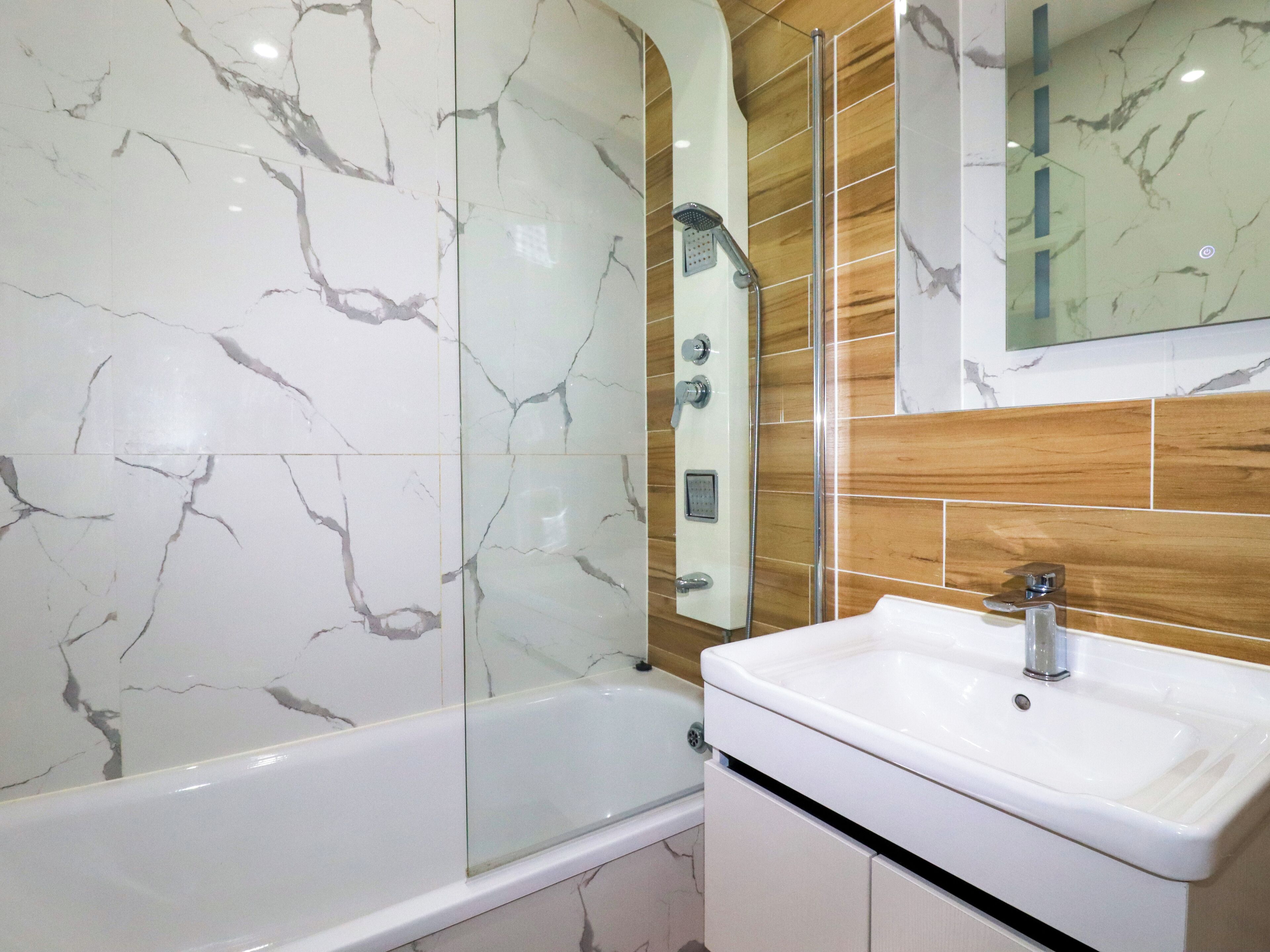 A bathroom with a bathtub, a shower, and a sink.