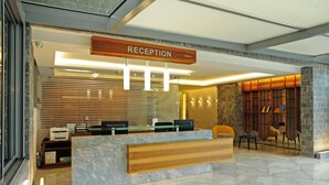 A reception area with a marble counter, wooden paneling, and a reception desk.