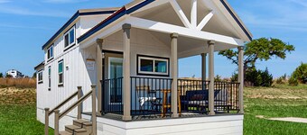 Modern tiny home with loft, kitchen, cozy patio and shared pools, great location